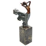 A patinated bronze figure modelled as lady in the wind, raised on a black marble base, Paris foundry