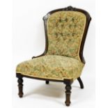 A Victorian walnut spoon back nursing chair, upholstered in button back floral fabric, raised on tur