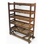 An early 20thC stained pine industrial trolley, with five slatted shelves, on castors, bears label t