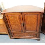 A mahogany and cross banded corner television cabinet, the top with two hinged doors beneath a fall,