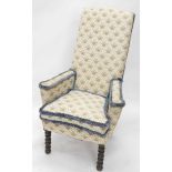 An oak armchair, upholstered in cream and gold fabric with blue pipping, on turned legs.