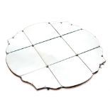 A decorative wall mirror, of floral outline, set with floral rosettes, with nine sections of glass,