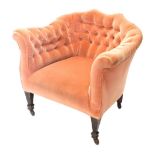 An Edwardian tub chair, upholstered in buttoned pink fabric, on square tapered legs with ceramic cas