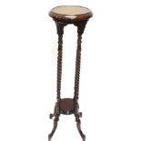 A hardwood plant stand, the circular top with a moulded edge, on spirally turned supports with under