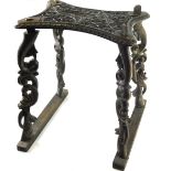 A heavily carved Eastern stool, with inverted top, profusely decorated with birds and scrolls on hea