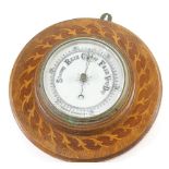 A 20thC oak cased aneroid wall barometer, with 12cm diameter dial, in elaborate inlaid scroll and fl