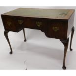 A walnut writing table, the rectangular top with a green leather inset above three drawers with cabr