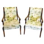 A pair of mahogany open armchairs, each with a reeded frame, upholstered in floral fabric, on sabre