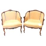 A pair of 19thC French mahogany show framed armchairs, upholstered in beige fabric on cabriole legs