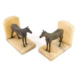 A pair golden onyx horse bookends, with shaped tops, 13cm high.