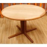 A Danish teak extending dining table, the circular top with shaped edge on a central column and tape