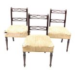 A set of three late George III mahogany dining chairs, each with two pierced rails on reeded support
