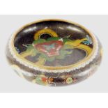 A Chinese cloisonne bowl, the compressed circular body profusely decorated with a dragon, on a black