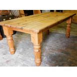 A pine farmhouse kitchen table, raised on turned and fluted legs, 79cm high, 198cm wide, 107cm deep.