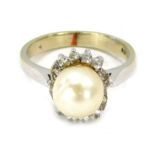 A dress ring with central cultured pearl, surrounded by round brilliant cut tiny diamonds, on a whit