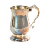 An Elizabeth II silver tankard, of plain form with acanthus leaf scroll handle on a stepped foot, ma