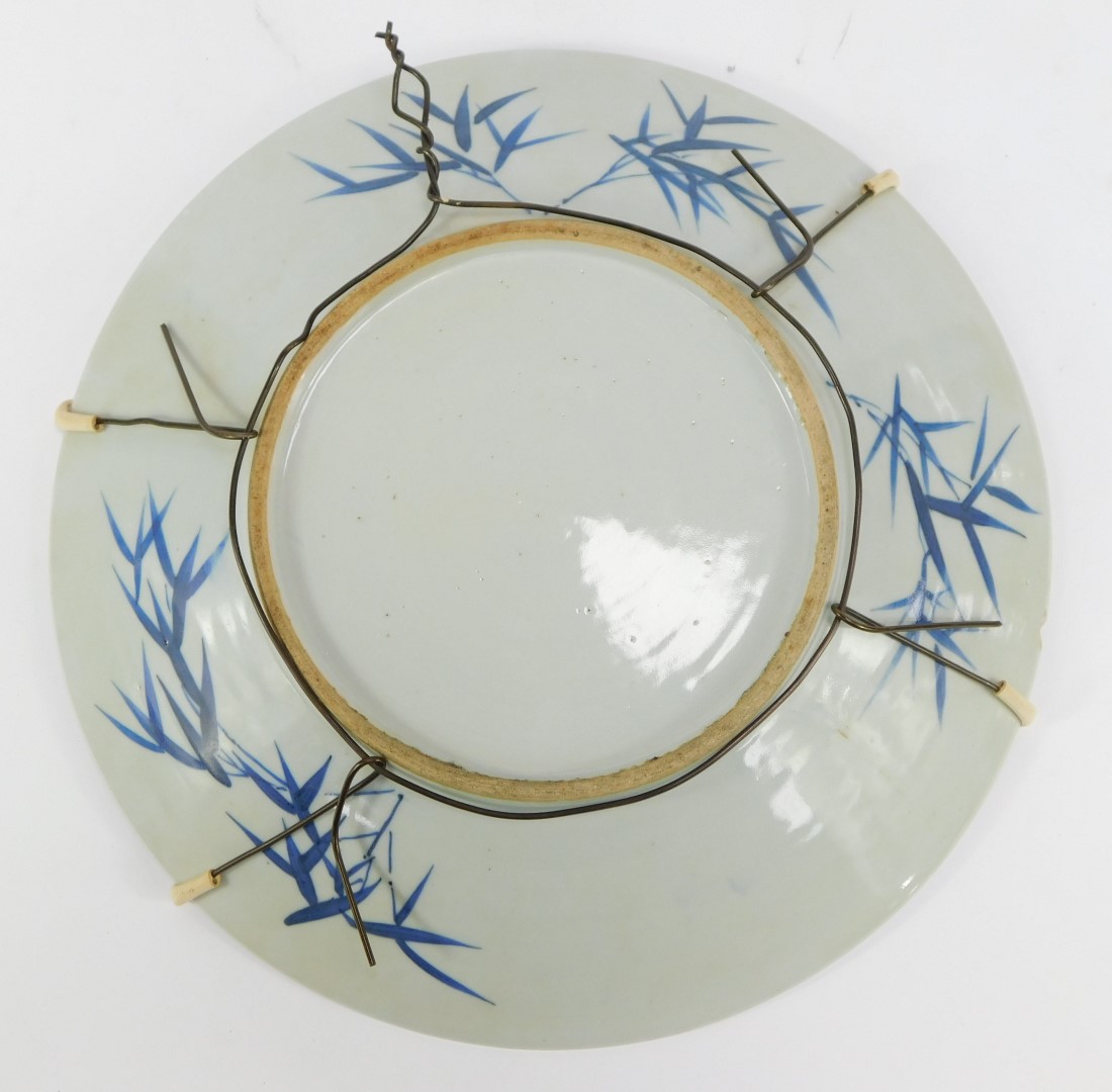 A 19thC Japanese blue and white charger, with Chinese figures with a floral border, 34cm diameter. - Image 2 of 2