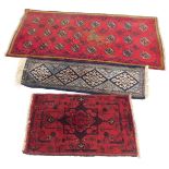 Three rugs, comprising a red Eastern style medallion rug, 120cm x 64cm, a blue four medallion runner