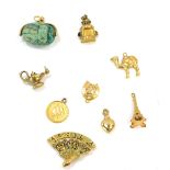A group of 9ct gold and other charms, comprising a swivel scarab beetle, love heart, Aladdin's lamp,