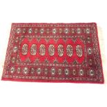 An Afghan or Pakistani rug, with seven guls to the centre, with similar design to the outer border,