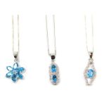 Three blue zircon and silver pendants and chains, comprising a six point cluster pendant, an Art Dec