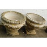 A pair of reconstituted stone planters, each with ribbed and foliate scroll detail, 51cm high, 52cm
