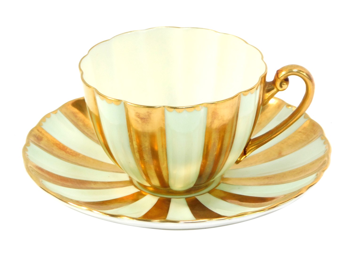 A Shelley cup and saucer, on a light green and gilt flared design. (AF)
