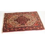 A Persian rug, on a red and cream ground, with large central medallion, and multi coloured borders,