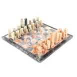 An alabaster chess set, with board, set with coloured pieces, 36cm wide.