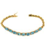 A blue zircon and diamond set line bracelet, set with nine oval cut blue zircons and twelve tiny dia