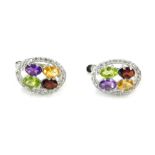 A pair of silver multi stone cluster earrings, the oval earring with outer CZ border and a red green