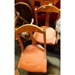 Two Victorian oak framed lounge chairs, each with a pink upholstered seat and carved daisy back. (2)