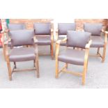 A set of six oak framed and leather studded carver chairs, each with dark purple leatherette seats,