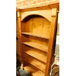 A pine bookcase, with arched top.