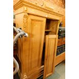 A pine two door wardrobe, with moulded cornice top, and carved Corinthian column support, on bun fee