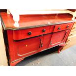 A red and black painted sideboard, with two drawers and two cupboard doors, on cabriole legs.