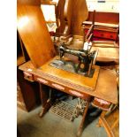 An oak Singer sewing machine and stand, serial number EA452461 with applied railway station badges.