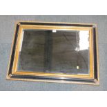 A blackened and gilt framed rectangular wall mirror.