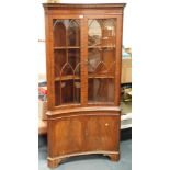 A mahogany concave corner cabinet.