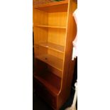A teak mid century bookcase, with bookshelf top above two cupboard doors on tapered legs.