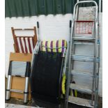 A striped deck chair, two outdoor chairs, pasting table, two aluminium step ladders and a telescopic