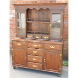 A stained pine dresser, with plate rack back, on sideboard base with six drawers and two cupboards,