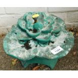 A green painted reconstituted stone lily pad water feature.