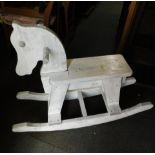 A child's wooden rocking horse, painted white, 75cm high.