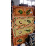 A set of four graduated painted boxes, each vibrantly decorated with fruit.