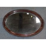 A mahogany framed oval wall mirror.