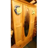 A pine single wardrobe, with central glazed door and applied sun crest, with single drawer.
