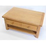 A light oak rectangular coffee table, with a double sided drawers, 50cm high, 70cm wide.