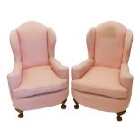 A pair of early 20thC walnut wing back chairs, each upholstered in a pink pattern fabric, on short c