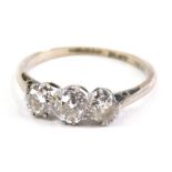 A three stone diamond ring, on part pierced shank, illusion set, marked PLAT, size J, 1.9g all in.